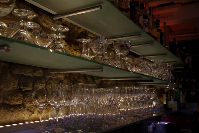 Glazen en warme verlichting boven de bar van 't Zeezotje