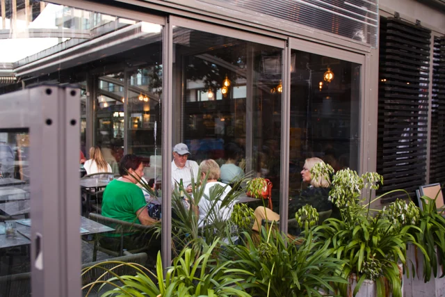 Gasten aan tafel op het overdekte terras van 't Zeezotje